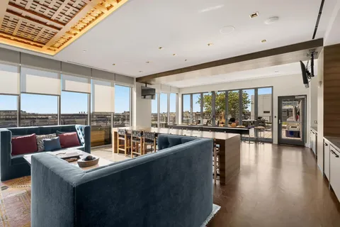 a large dining hall with stainless steel appliances granite countertop a sink and a white cabinets
