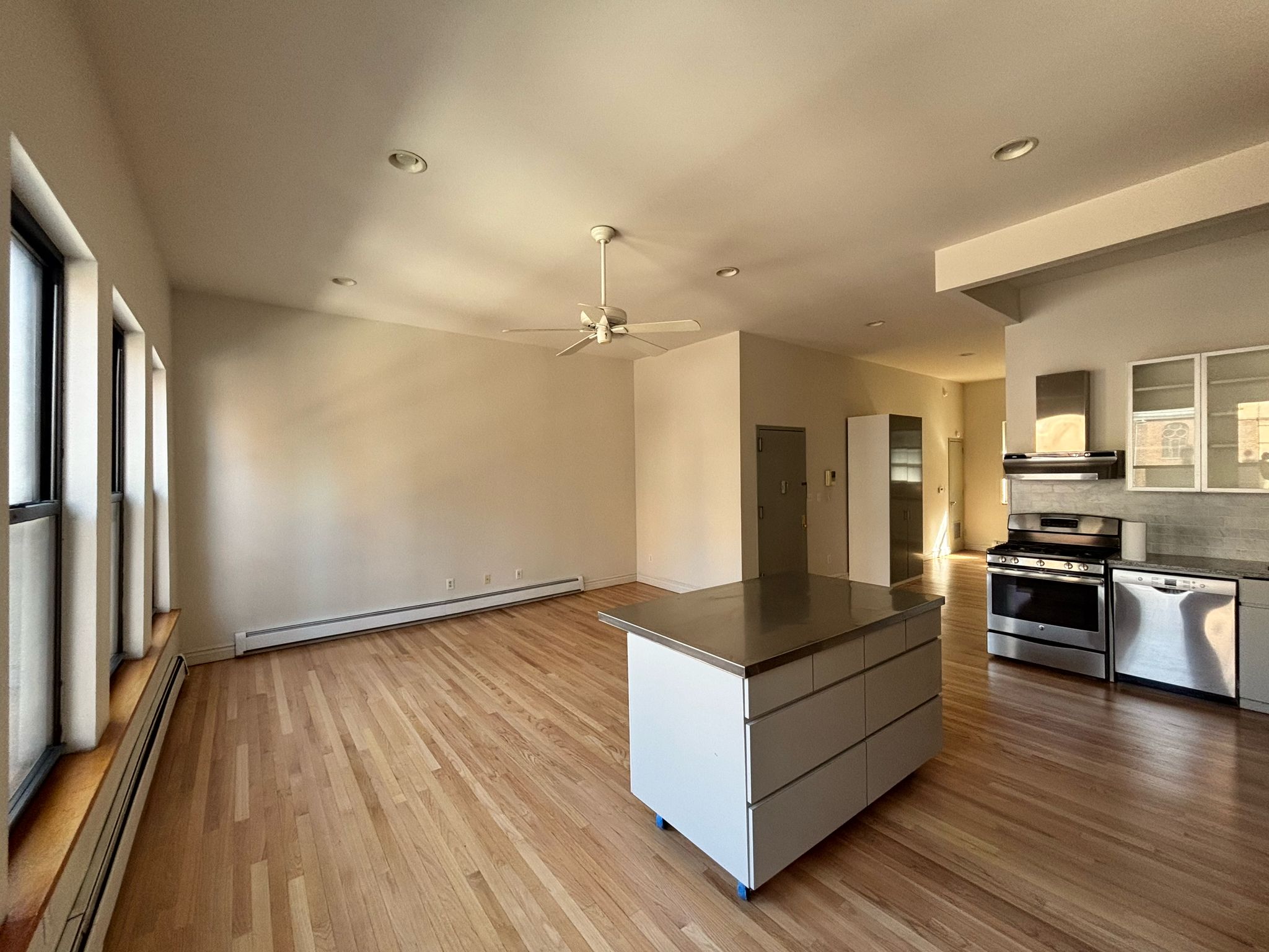 85 Division Street, Unit 4 Manhattan, NY 10002 - Photo 17 of 22 a kitchen with stainless steel appliances granite countertop a stove and a refrigerator
