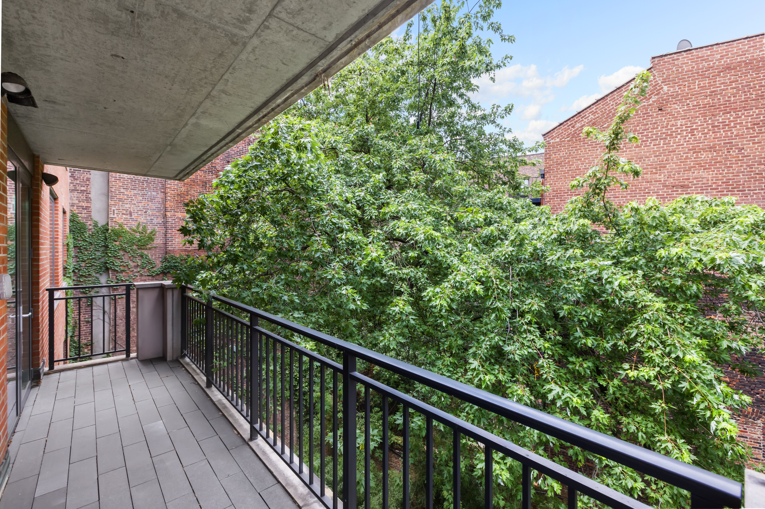 744 Greenwich Street, Unit 4 Manhattan, NY 10014 - Photo 24 of 34 a balcony with wooden floor and trees in the background