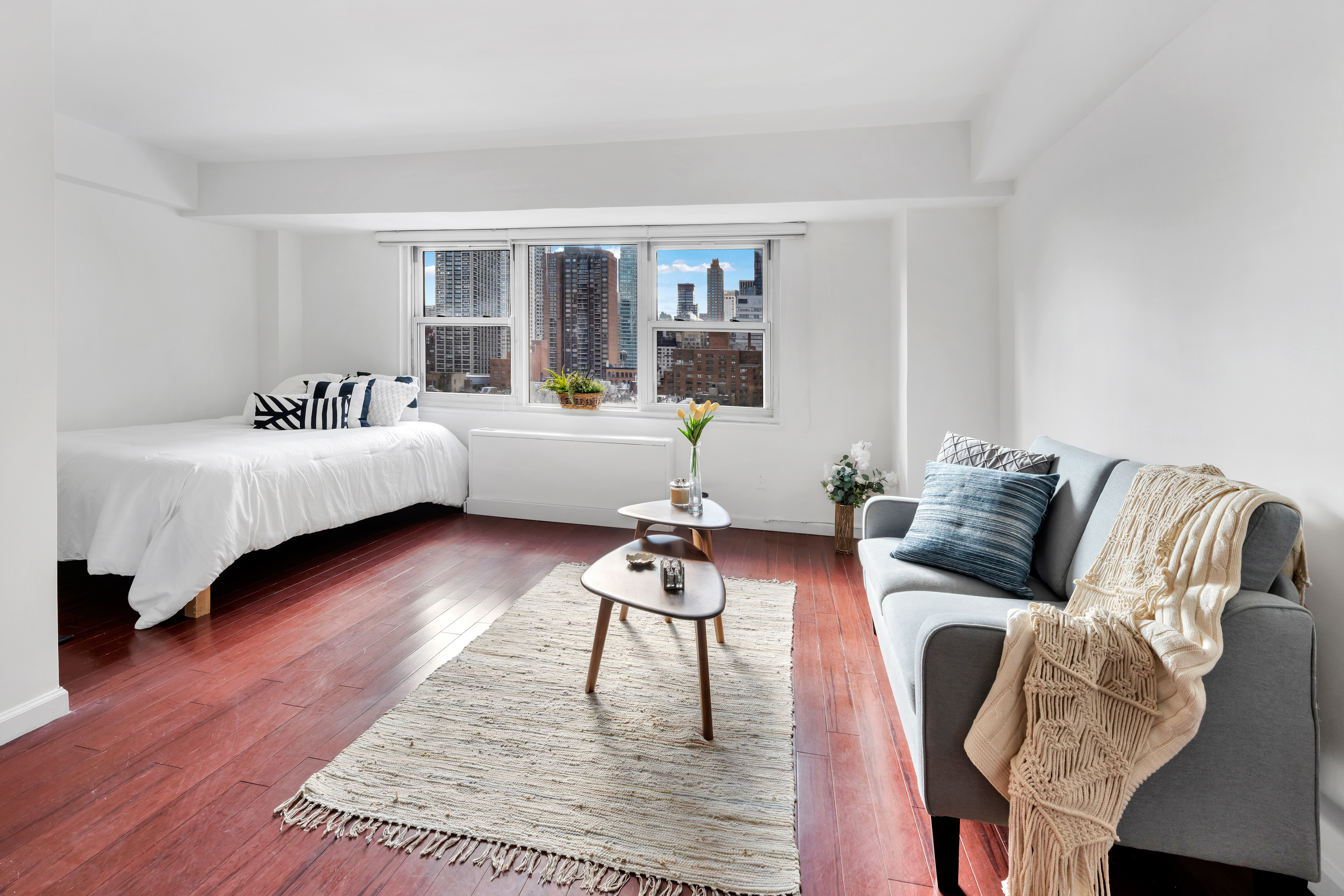 210 East 63rd Street, Unit 11F Manhattan, NY 10065 - Photo 3 of 14 a living room with furniture and wooden floor