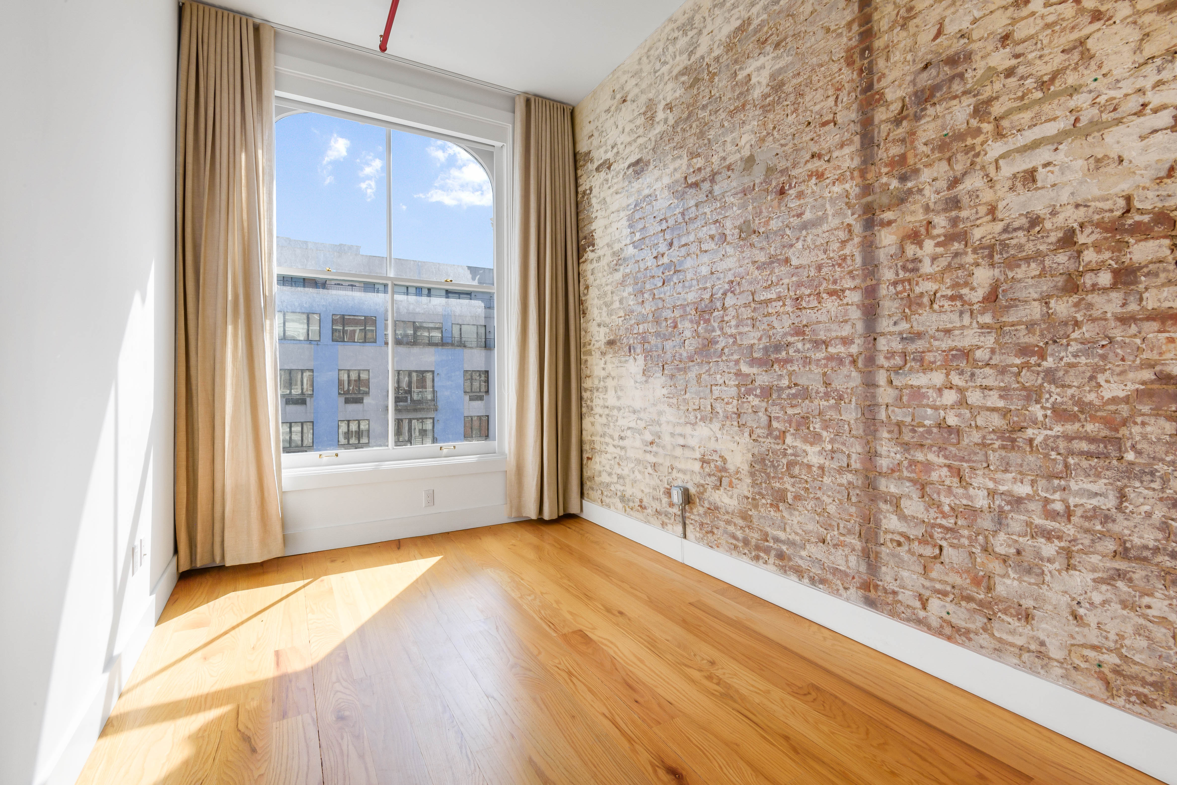 103 Broadway, Unit PH Brooklyn, NY 11249 - Photo 6 of 8 a view of empty room with a window and wooden floor