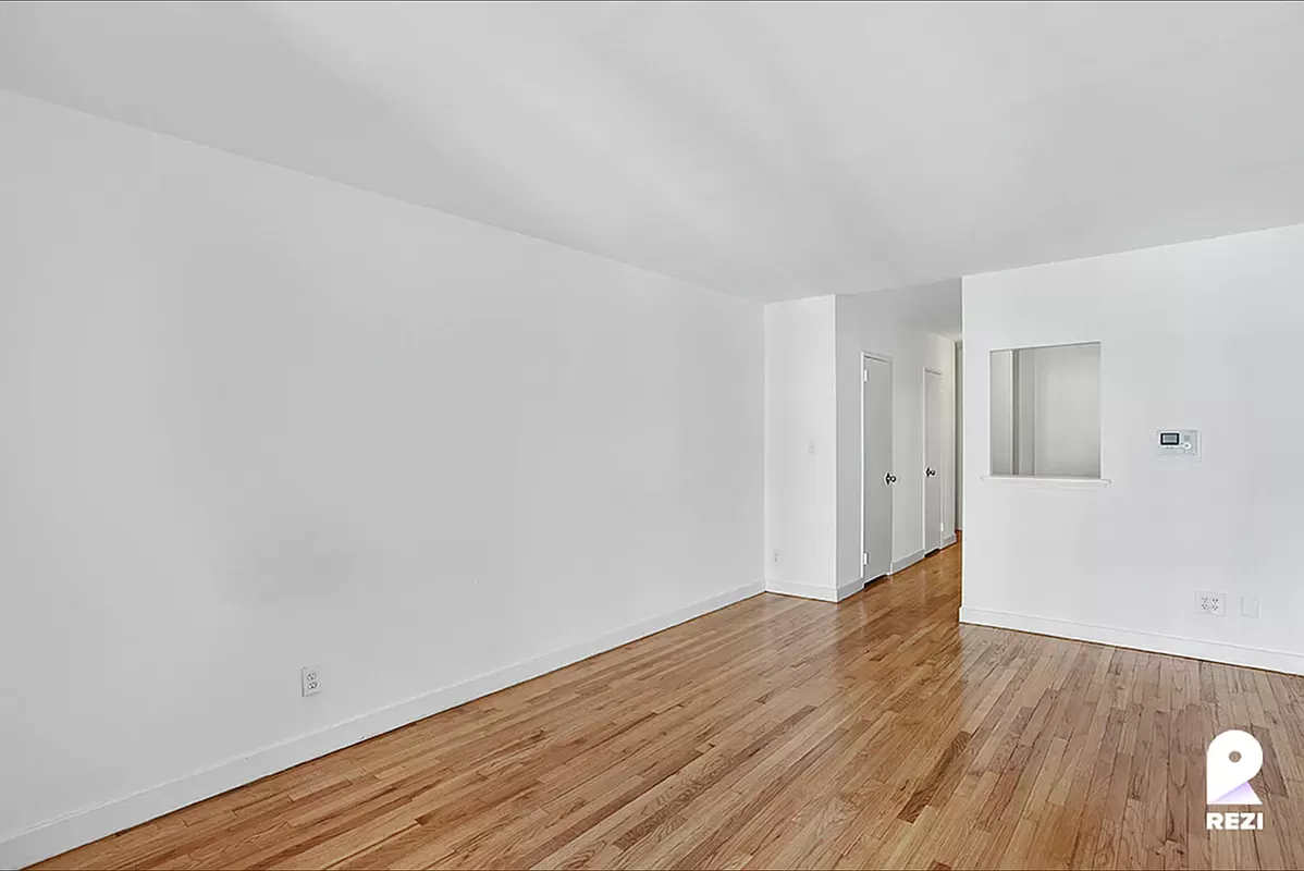 343 East 76th Street, Unit 4C Manhattan, NY 10021 - Photo 5 of 8 a view of an empty room with wooden floor