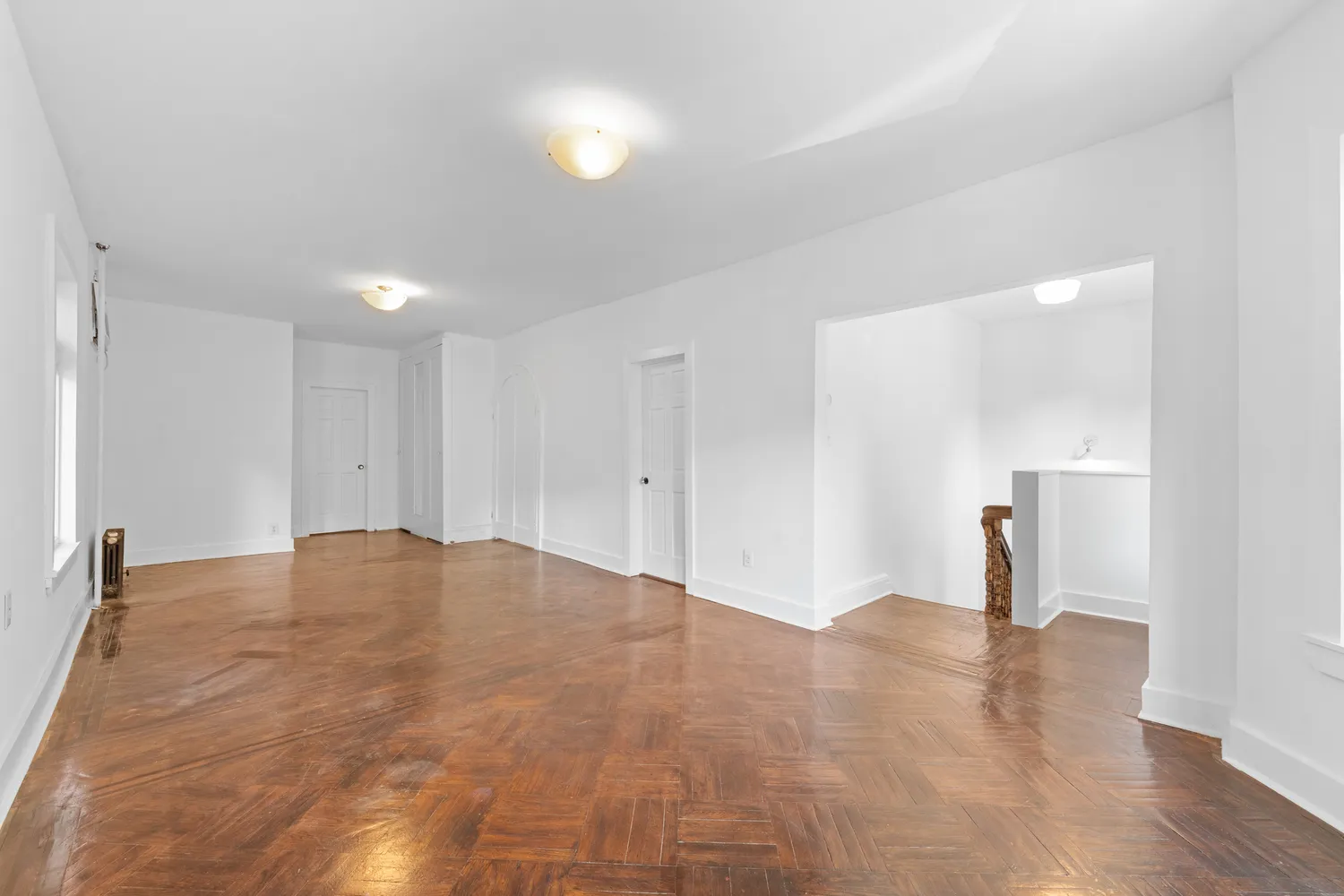 a view of empty room with wooden floor