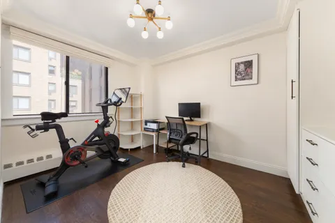 a view of a workspace with furniture and a window