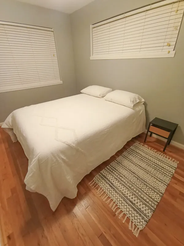 a bedroom with a bed and wooden floor