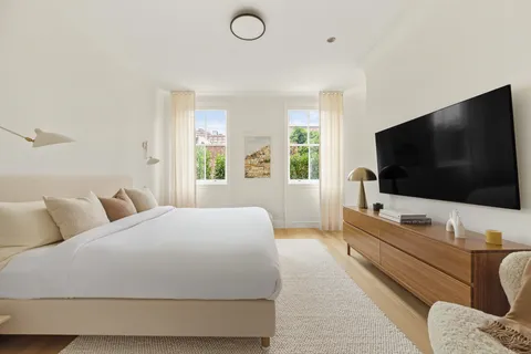 a bedroom with a bed and a flat screen tv