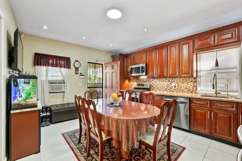 a kitchen with stainless steel appliances granite countertop a table chairs and a refrigerator