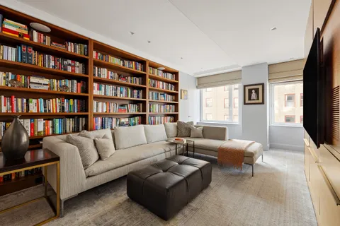 a living room with furniture and a book shelf