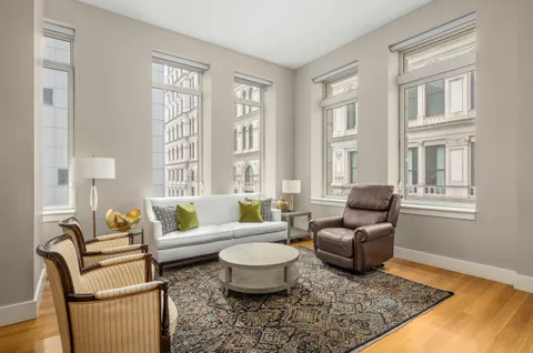 a living room with furniture two windows and a coffee table