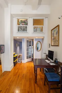 a workspace with furniture wall paintings and a window