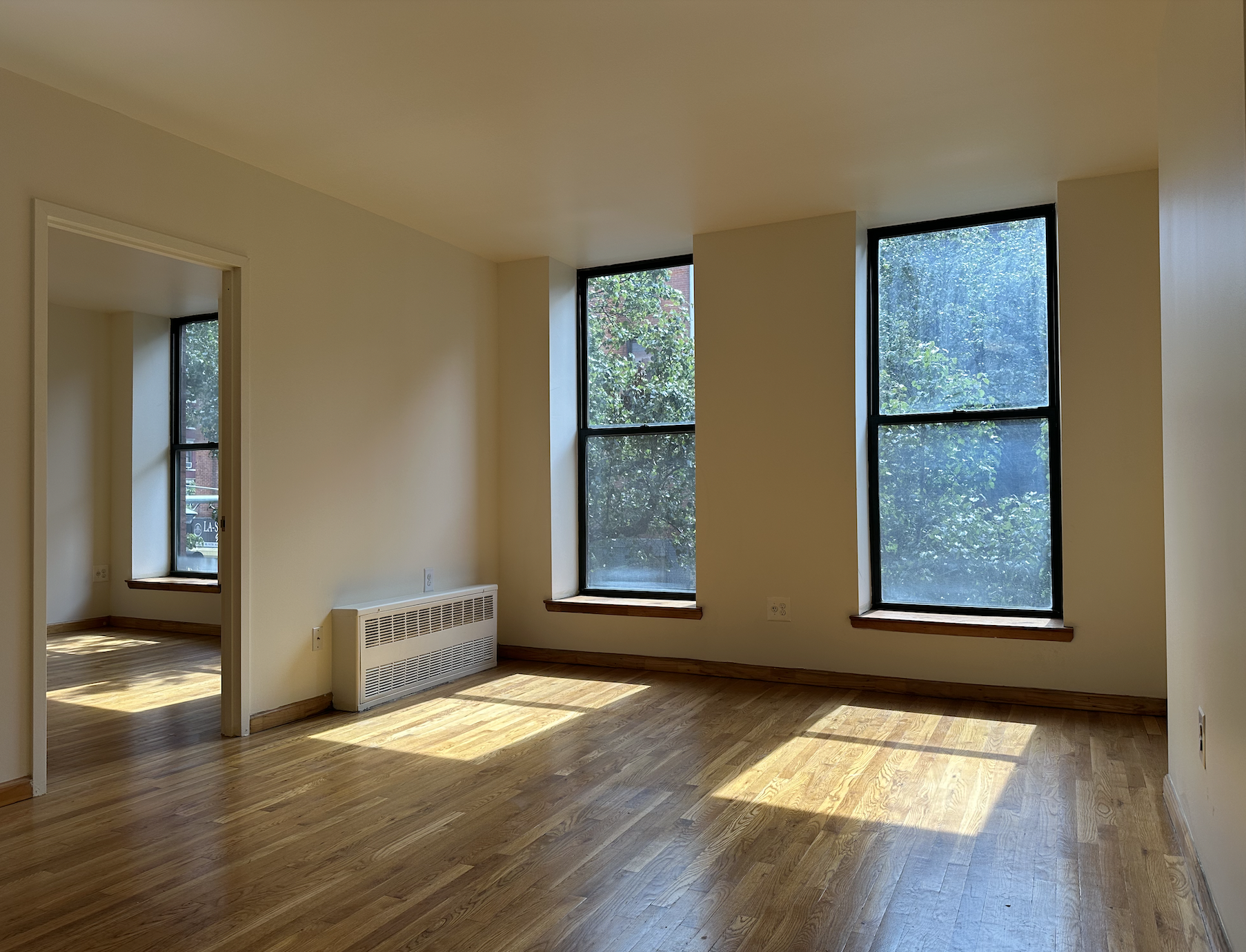 403 West 40th Street, Unit 2FE Manhattan, NY 10018 - Photo 2 of 12 a view of an empty room with wooden floor and a window