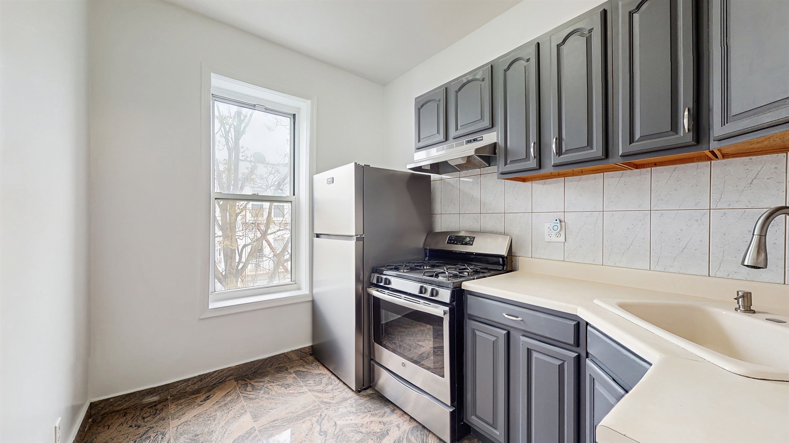 454 77th Street, Unit 3 Brooklyn, NY 11209 - Photo 2 of 25 a kitchen with stainless steel appliances granite countertop a sink stove and microwave