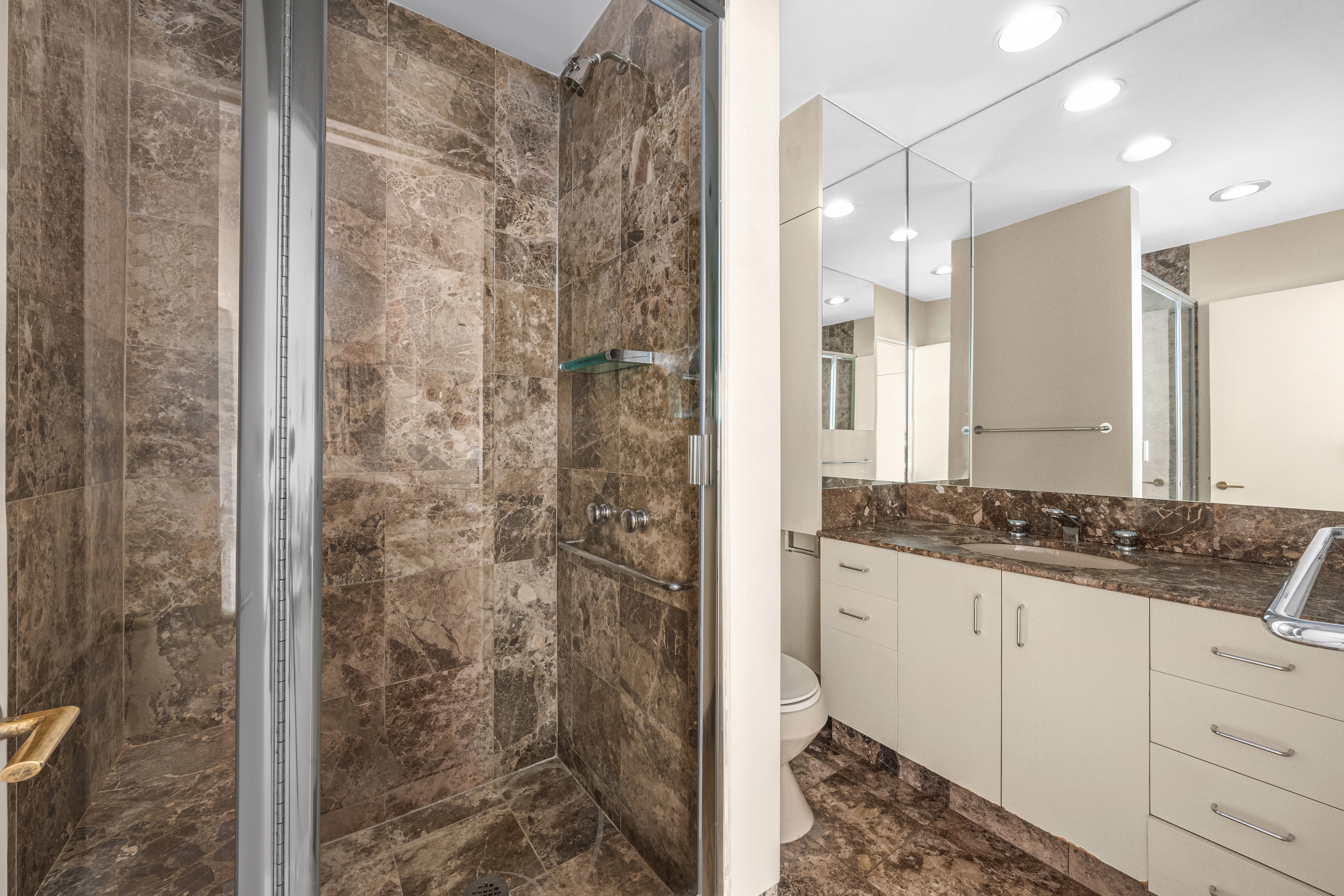 475 Park Avenue, Unit 11E Manhattan, NY 10022 - Photo 5 of 9 a bathroom with a granite countertop shower a sink and a mirror