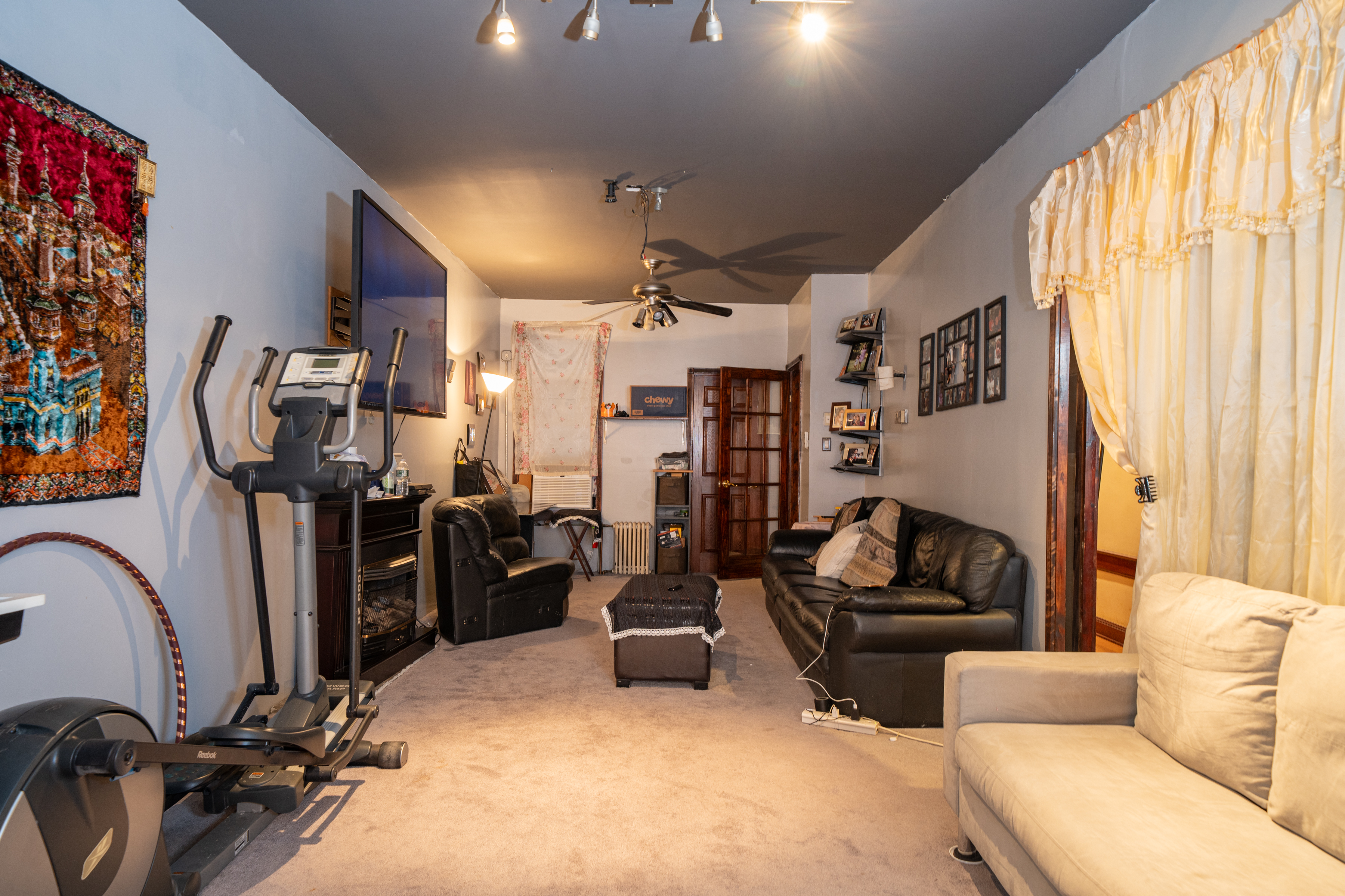 415 84th Street Brooklyn, NY 11209 - Photo 2 of 17 a living room with furniture a flat screen tv and a large window