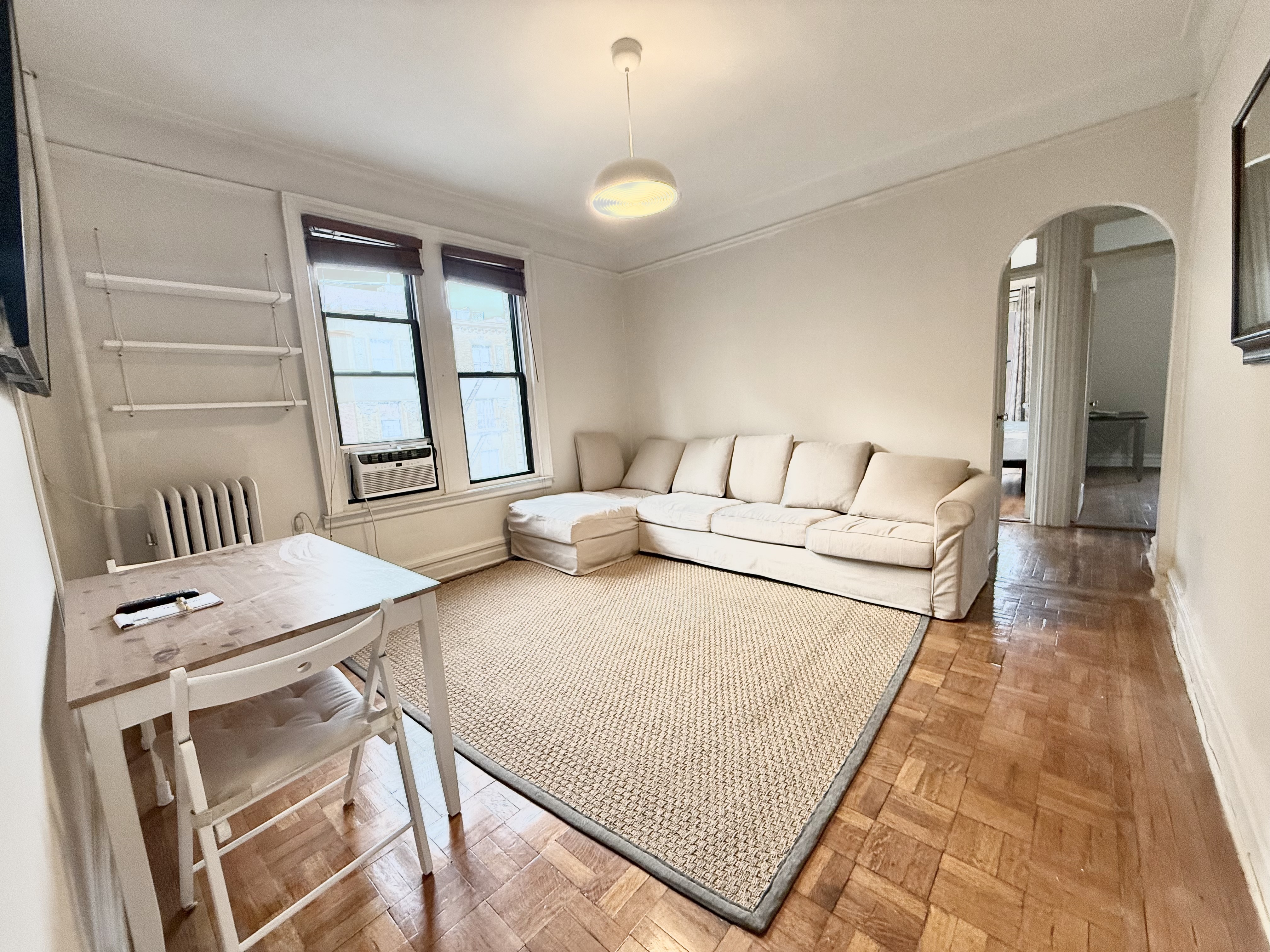 170 Claremont Avenue, Unit 19 Manhattan, NY 10027 - Photo 2 of 9 a living room with furniture and a window