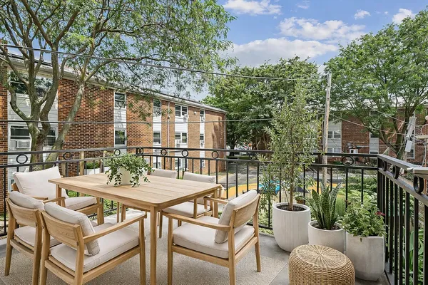 a view of a patio with couches table and chairs and potted plants