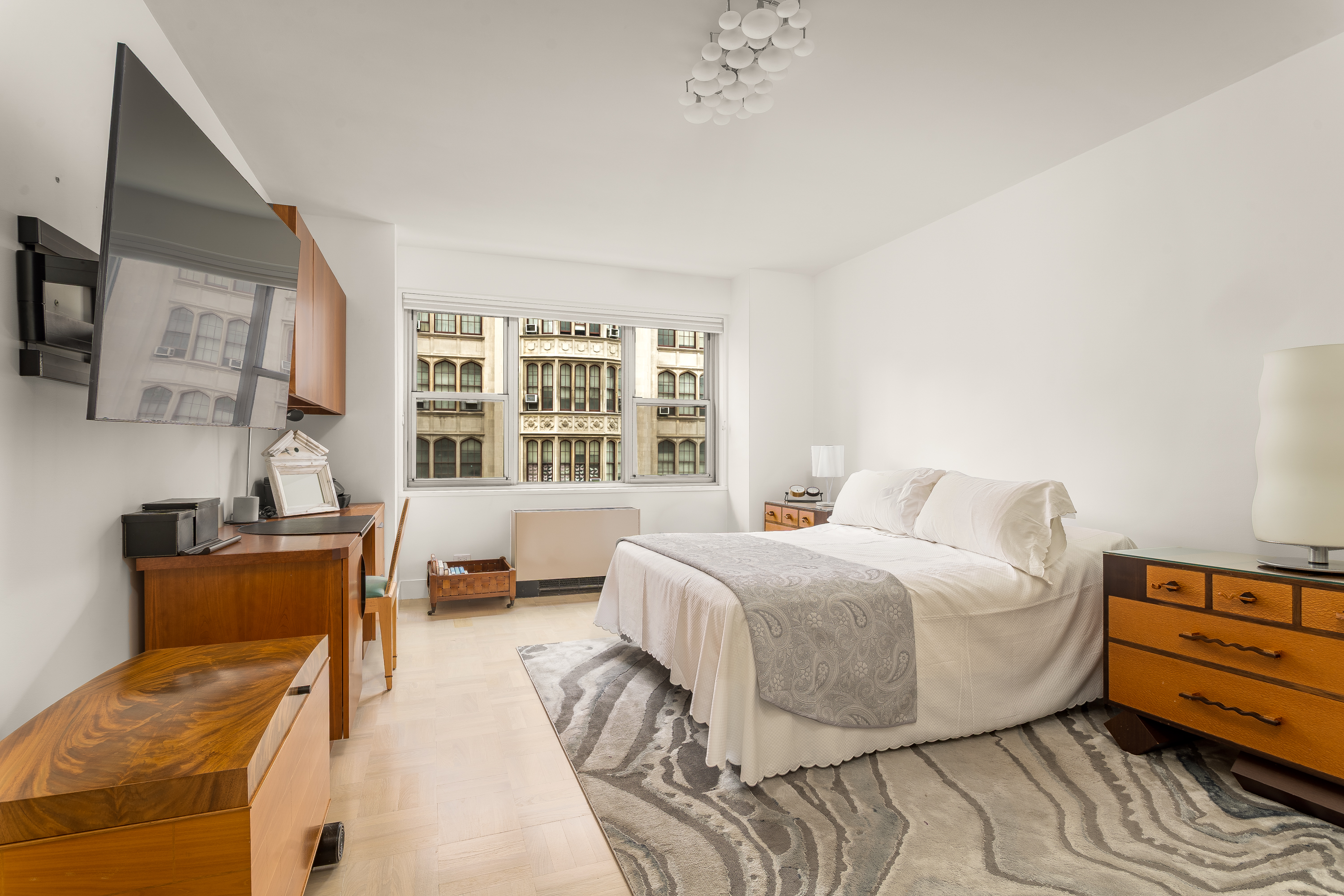 150 East 69th Street, Unit 5C Manhattan, NY 10021 - Photo 7 of 15 a bedroom with a bed and wooden floor