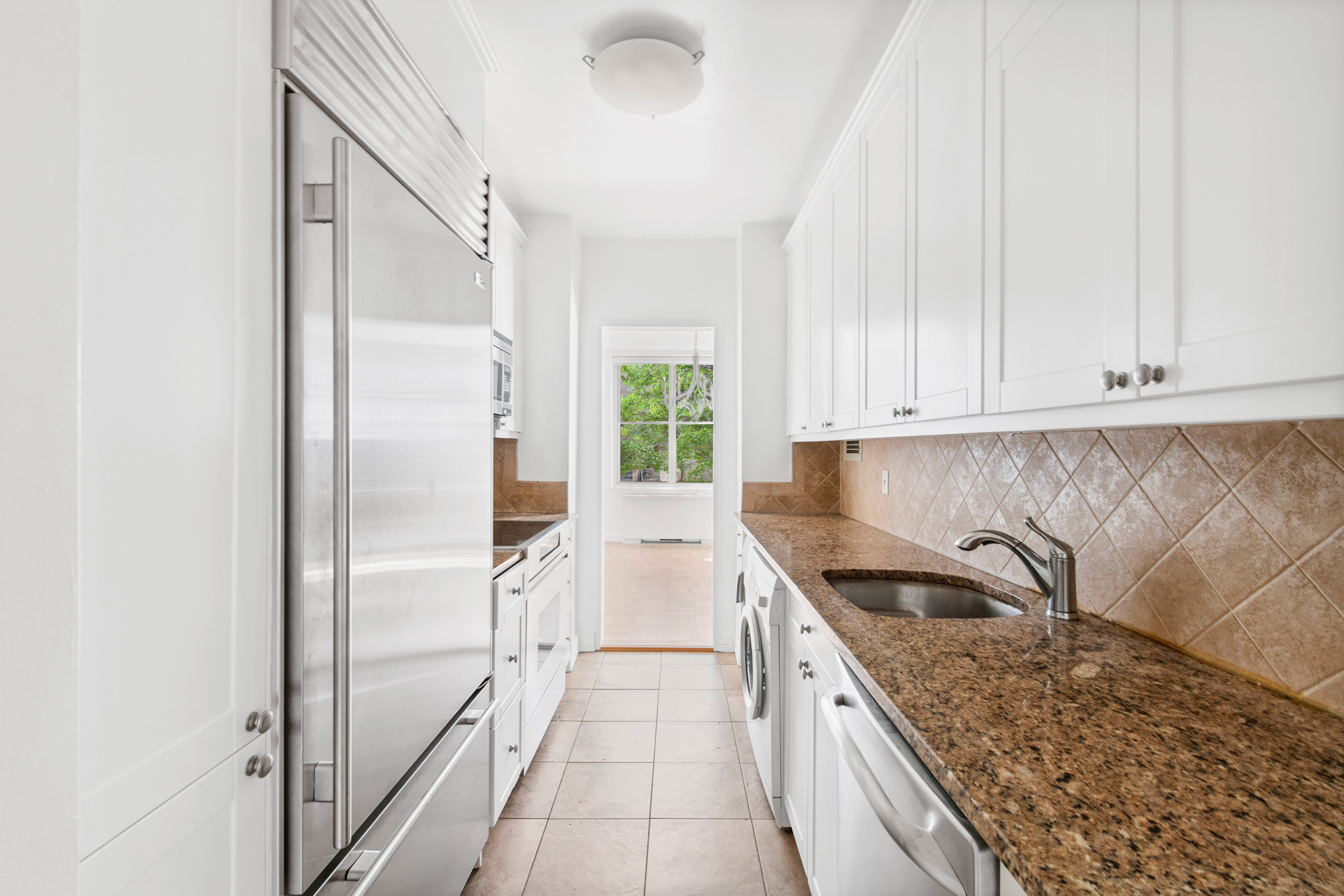 201 East 62nd Street, Unit 2C Manhattan, NY 10065 - Photo 7 of 14 a kitchen with granite countertop a sink stainless steel appliances and cabinets