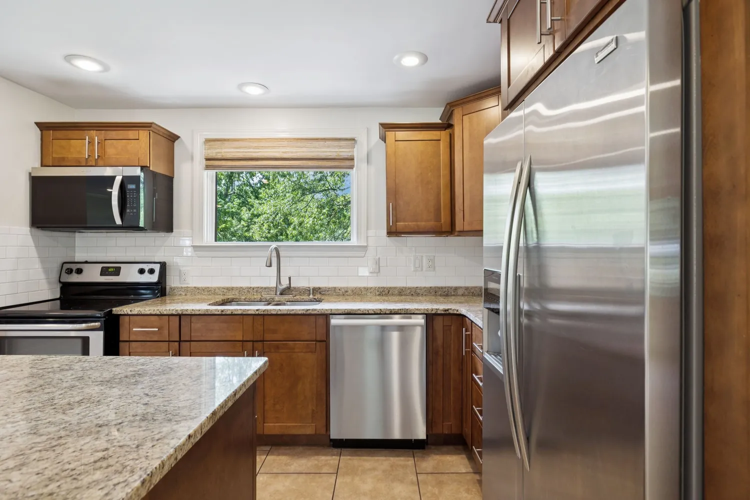a kitchen with stainless steel appliances granite countertop a sink stove and refrigerator