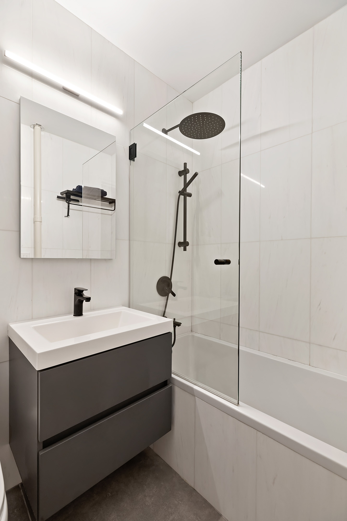 434 East 58th Street, Unit 6B Manhattan, NY 10022 - Photo 5 of 6 a bathroom with a sink a mirror and a shower