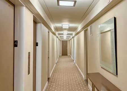 a view of a hallway with wooden floor and staircase
