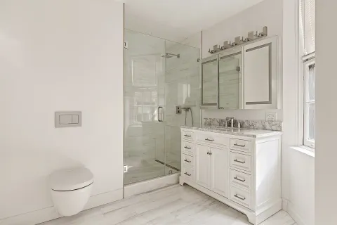 a bathroom with a granite countertop sink toilet and shower