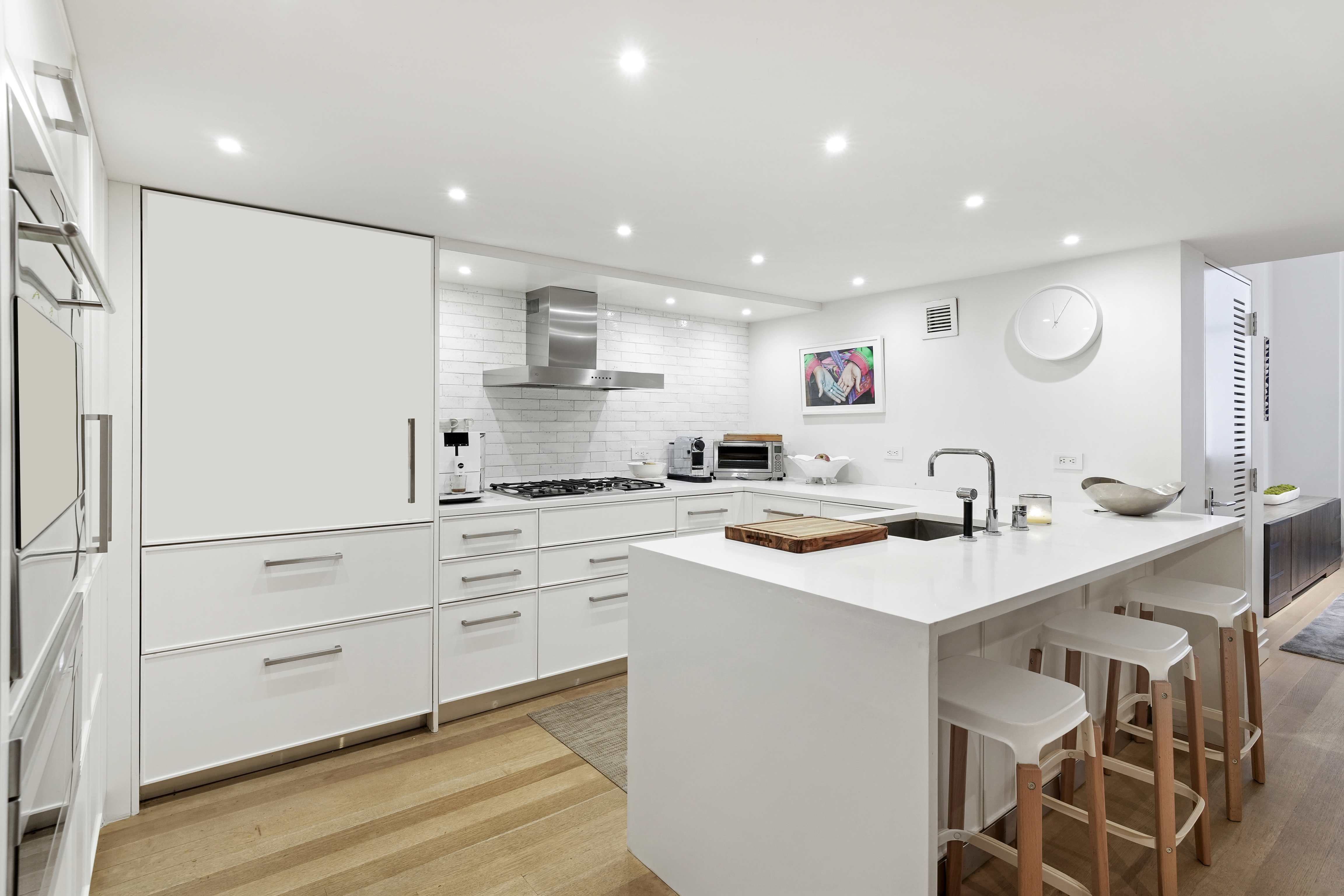 421 Hudson Street, Unit 221 Manhattan, NY 10014 - Photo 3 of 12 a kitchen with a sink stainless steel appliances and white cabinets