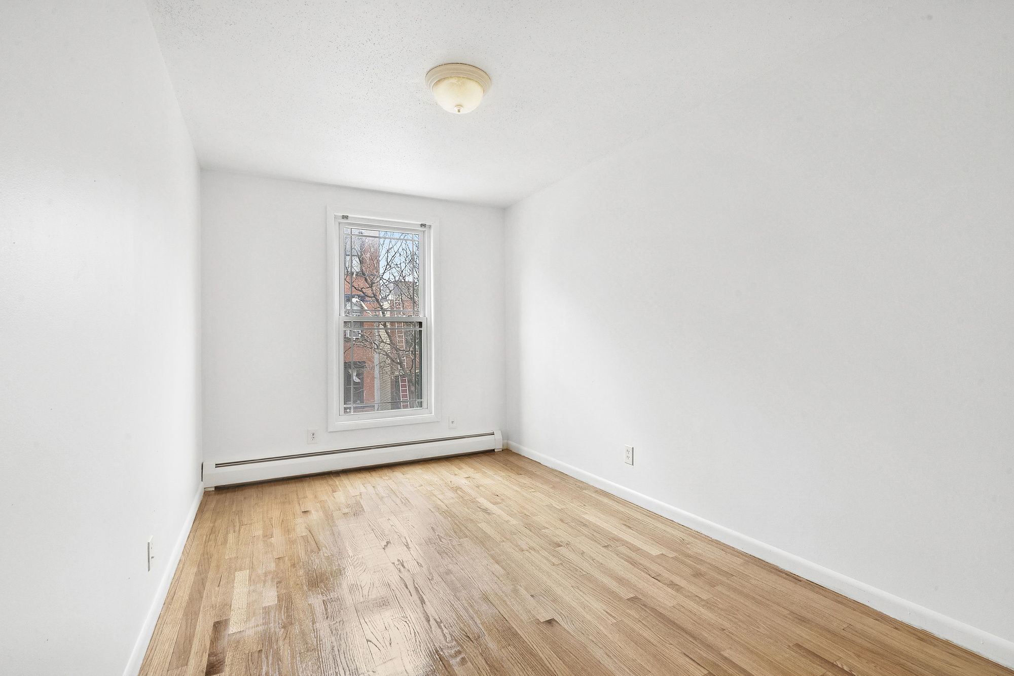 97 Baltic Street, Unit 3 Brooklyn, NY 11201 - Photo 5 of 9 an empty room with wooden floor and windows