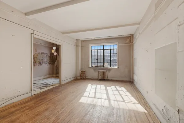 wooden floor in an empty room with a window