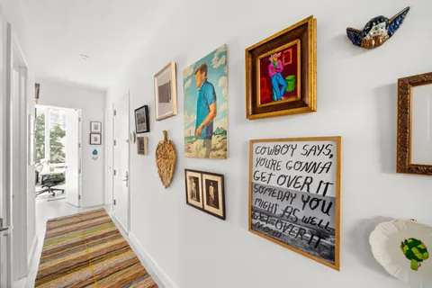 a hallway with painting and a book shelf