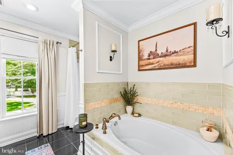 a bathroom with a granite countertop toilet a sink a mirror a window and shower