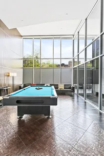a room with pool table and glass windows