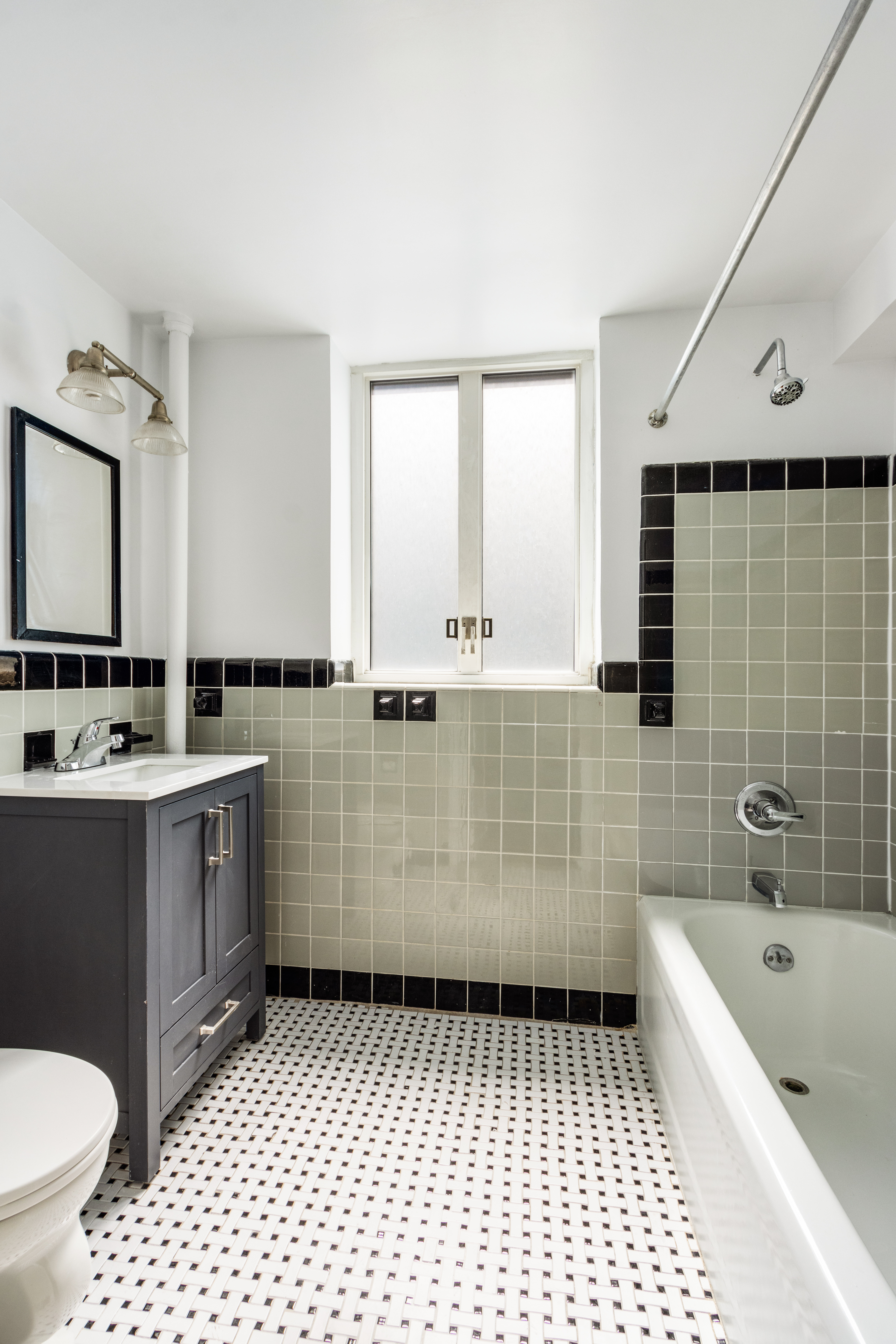 200 West 20th Street, Unit 206 Manhattan, NY 10011 - Photo 4 of 8 a bathroom with a granite countertop sink toilet a mirror and bathtub