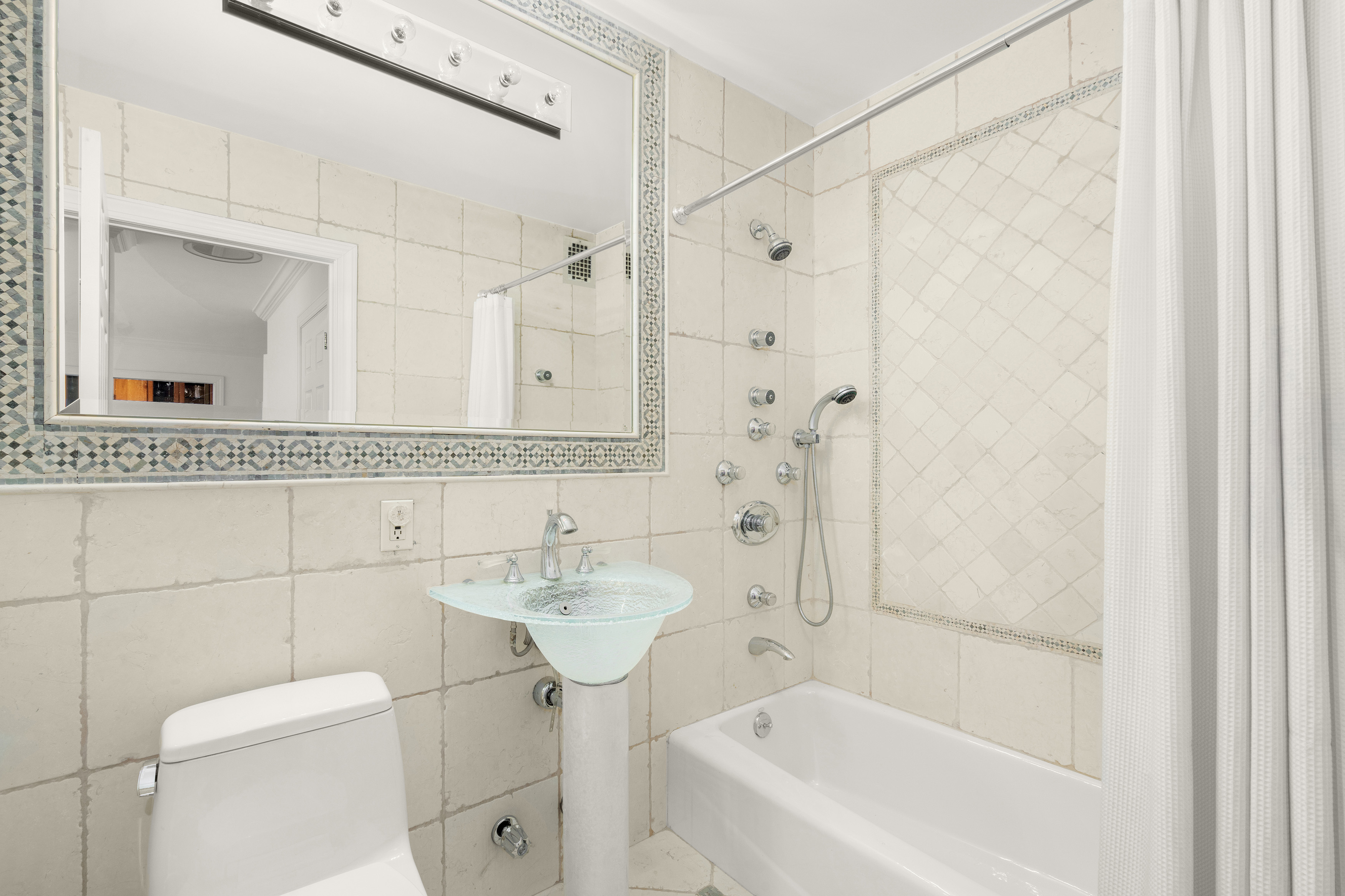 207 East 74th Street, Unit 11E Manhattan, NY 10021 - Photo 14 of 20 a bathroom with a sink a toilet and shower