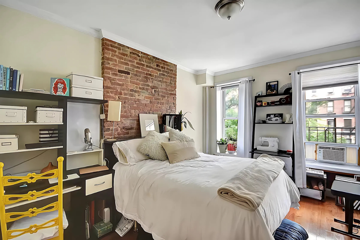 1273 1st Avenue, Unit 8 Manhattan, NY 10065 - Photo 1 of 6 a bedroom with a bed a dresser and a book shelf