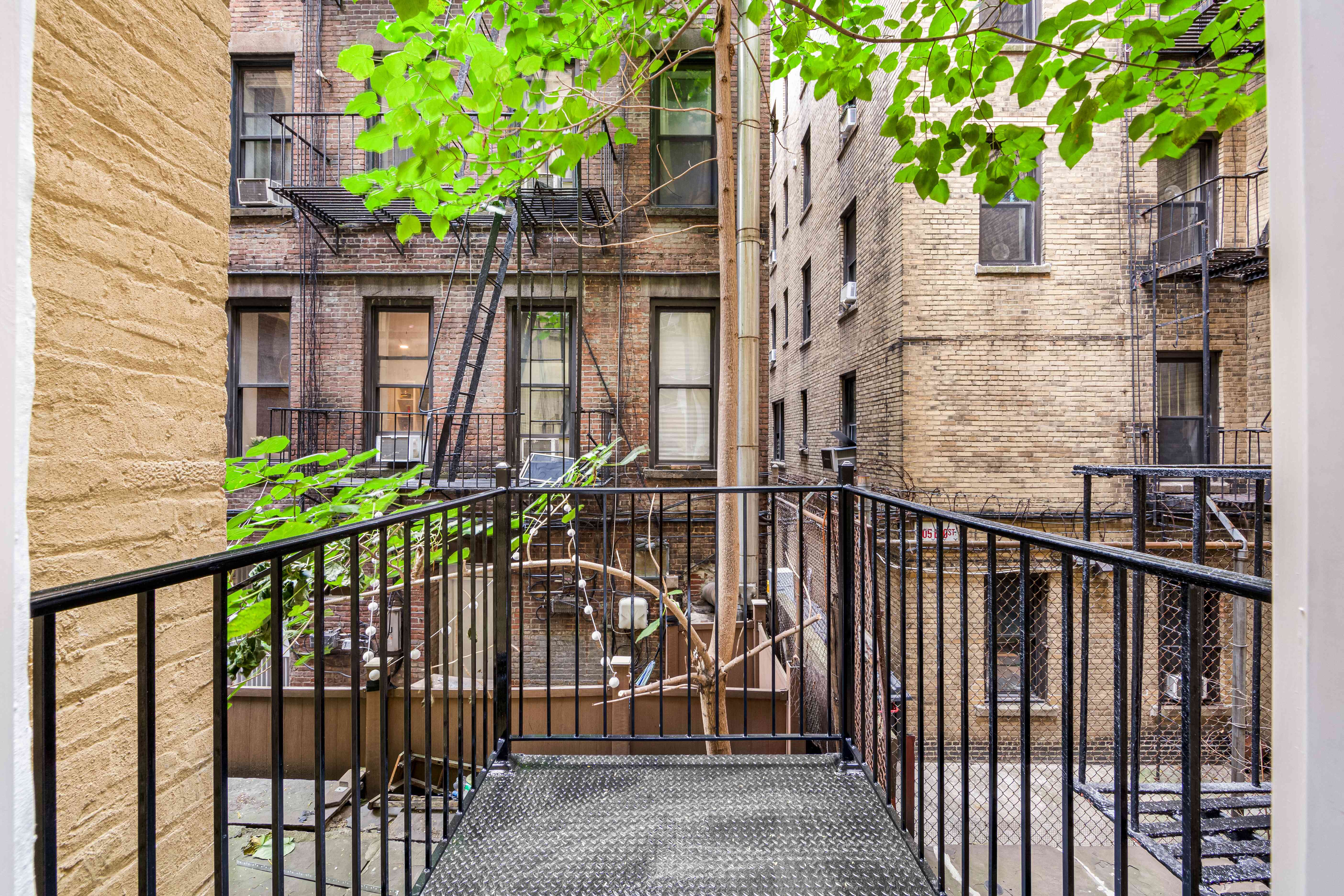 304 East 11th Street, Unit 1C Manhattan, NY 10003 - Photo 13 of 16 a view of a house with a small yard and a large tree