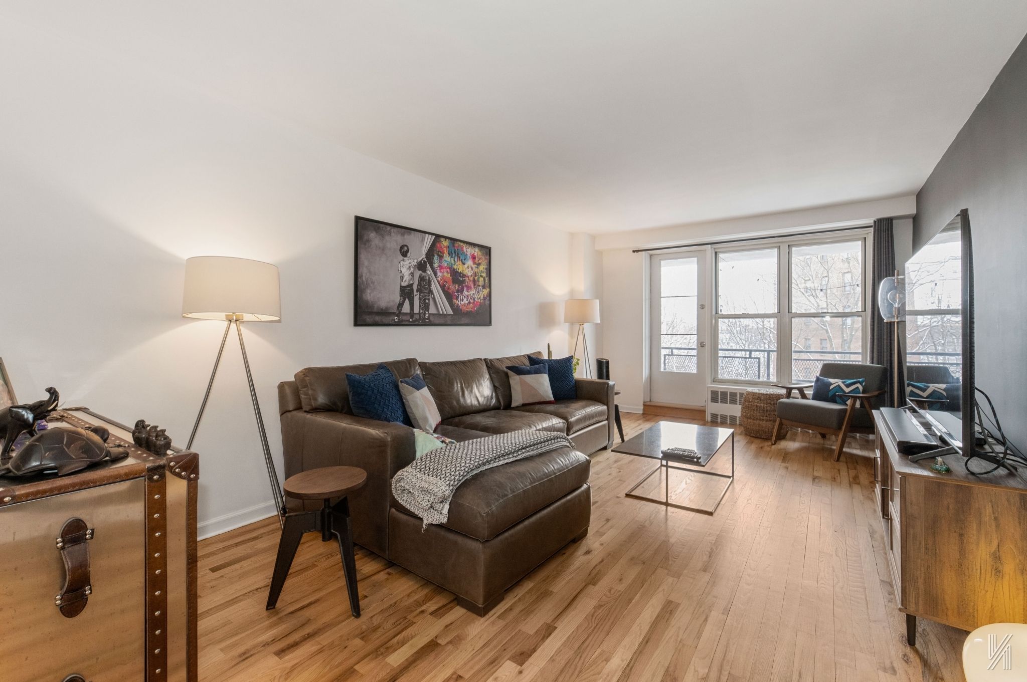 35-50 85th Street, Unit 7H Queens, NY 11372 - Photo 2 of 16 a living room with furniture and a flat screen tv with wooden floor