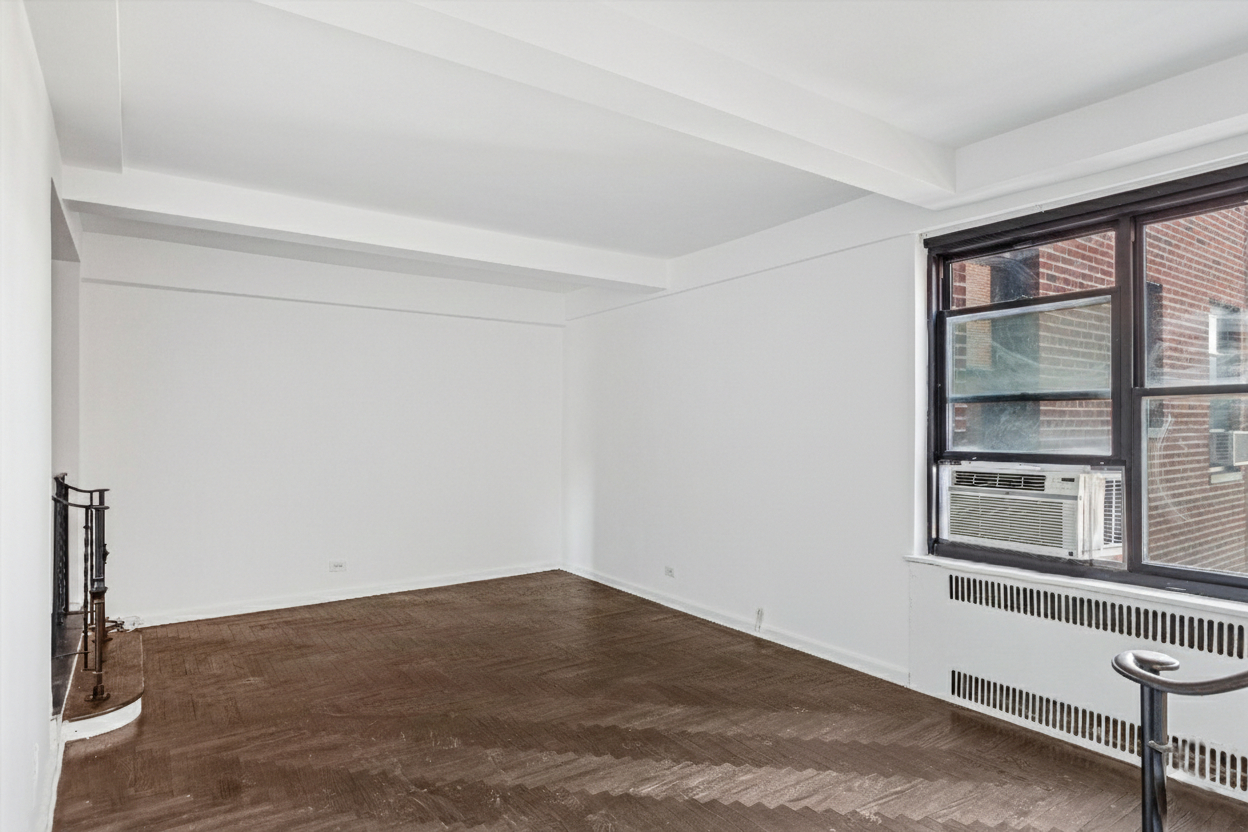 70 Park Terrace West, Unit E74 Manhattan, NY 10034 - Photo 4 of 27 a view of empty room with wooden floor and fan