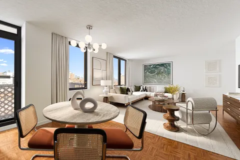 a living room with furniture a large window and a table