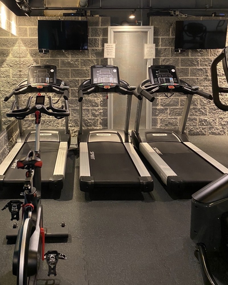 201 West 70th Street, Unit 17A Manhattan, NY 10023 - Photo 11 of 20 a room with gym equipment and flat screen tv