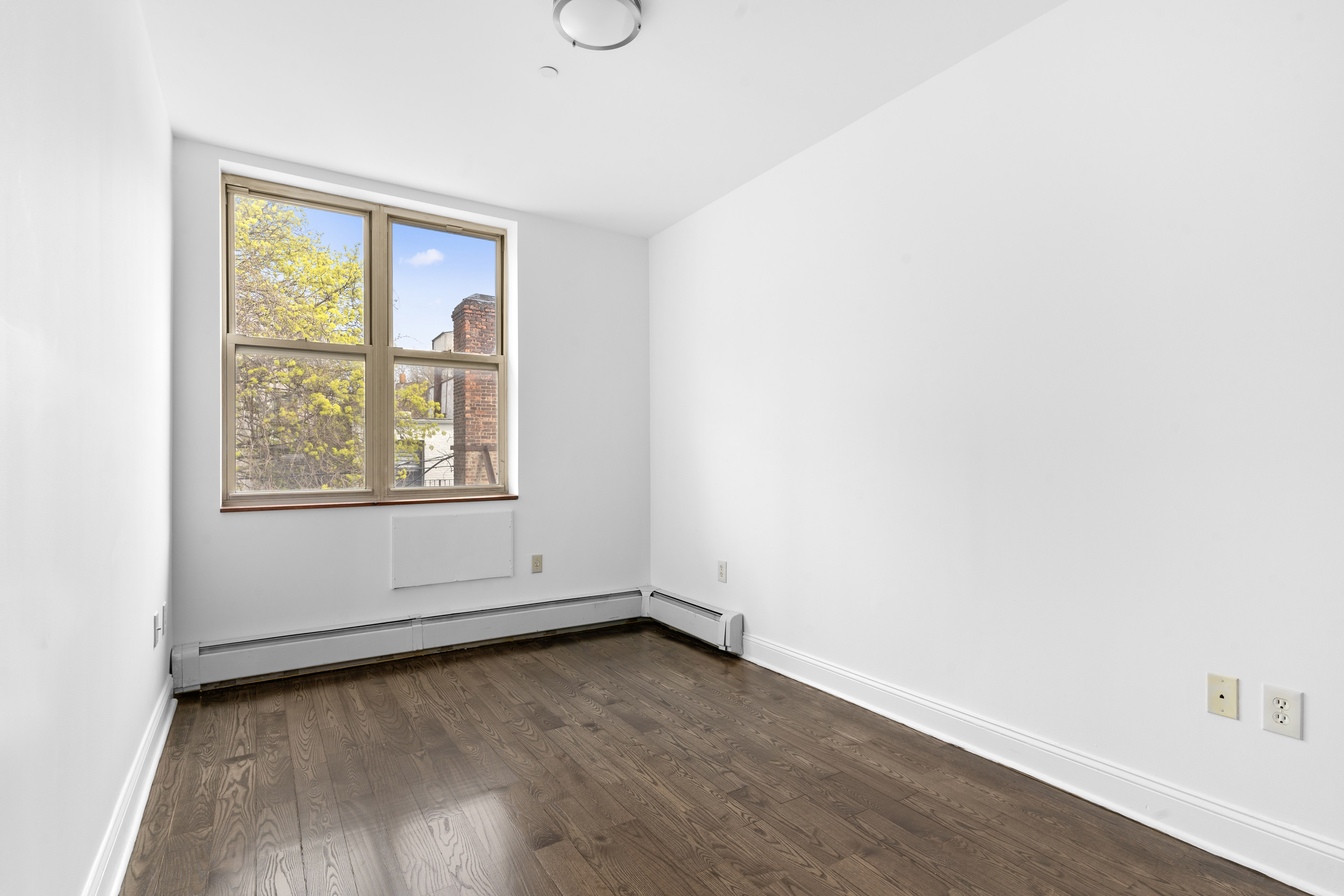 269 8th Street, Unit 2R Brooklyn, NY 11215 - Photo 9 of 14 an empty room with wooden floor and windows