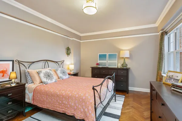 a bedroom with a bed and dresser with mirror