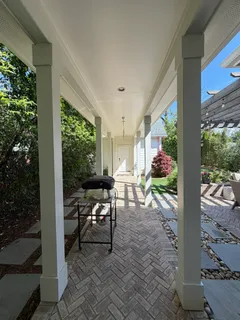 a view of a porch with chairs and potted plants