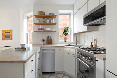 a kitchen with cabinets appliances a sink and a window