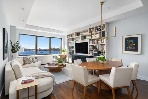 a living room with furniture a flat screen tv and a large window