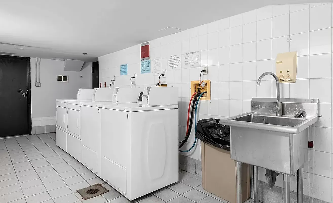 1582 York Avenue, Unit 2C Manhattan, NY 10028 - Photo 6 of 12 a kitchen with a sink a stove and white cabinets