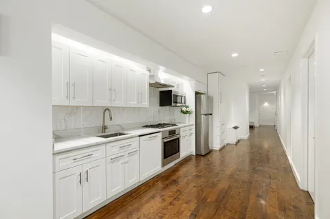 a kitchen with white cabinets and stainless steel appliances