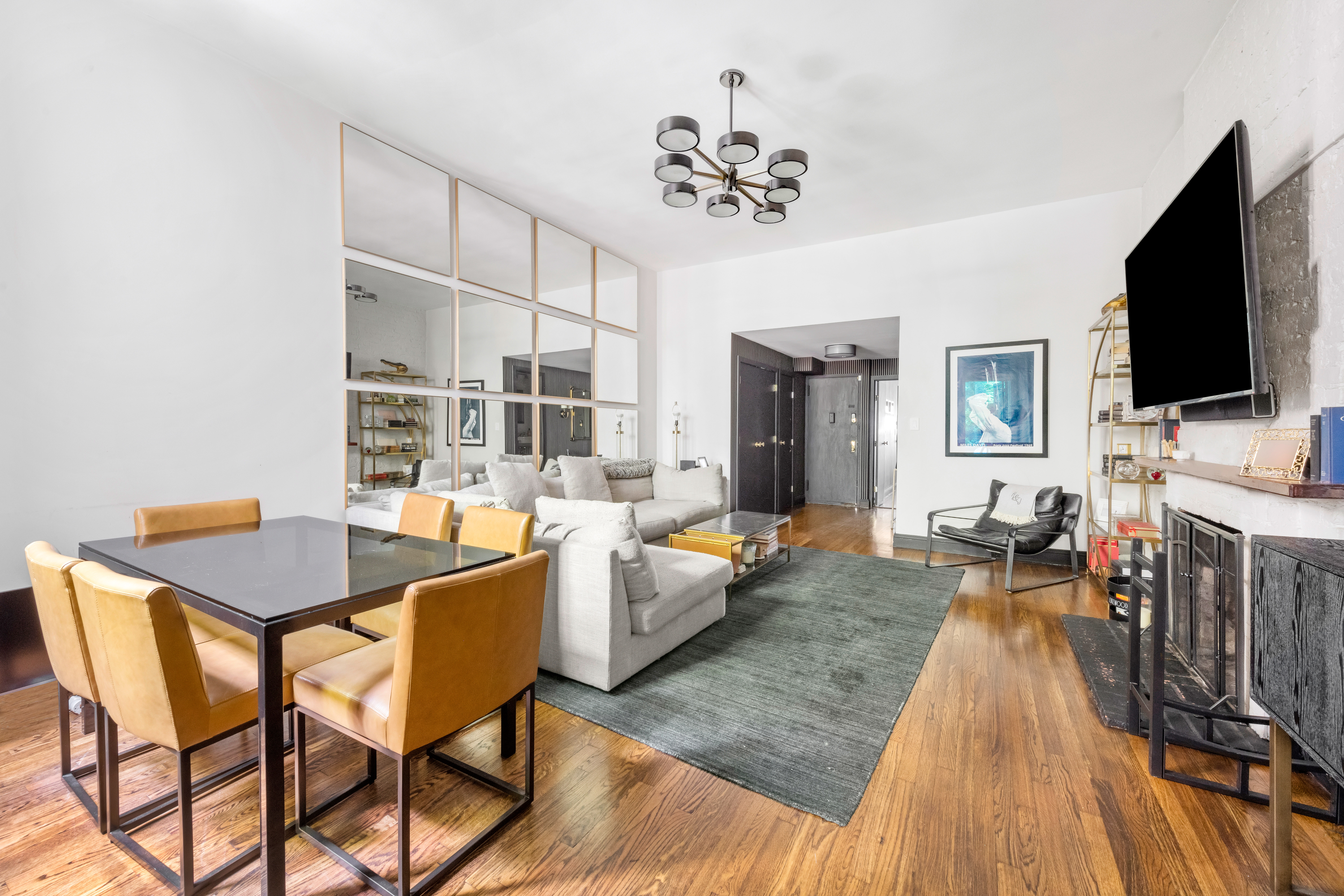 21 West 9th Street, Unit 1F Manhattan, NY 10011 - Photo 2 of 11 a living room with furniture and a flat screen tv