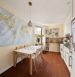 a kitchen with stainless steel appliances granite countertop a stove top oven a sink dishwasher and a dining table with wooden floor