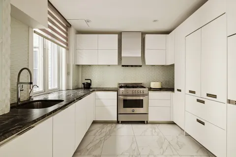 a kitchen with stainless steel appliances a sink a stove and white cabinets